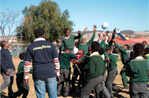 Thobile Antoni leads a group of learners immersed in a game of touch Rugby 