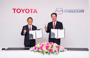 We've sealed the deal, Toyota President and CEO, Akio Toyoda (left) and Mazda President and CEO, Masamichi Kogai, seem to be saying as they proudly display the signed documents at the ceremony in Tokyo...Friday