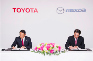 Toyota President and CEO, Akio Toyoda (left) and Mazda President and CEO, Masamichi Kogai, signing the partnership agreement at a ceremony in Tokyo...Friday